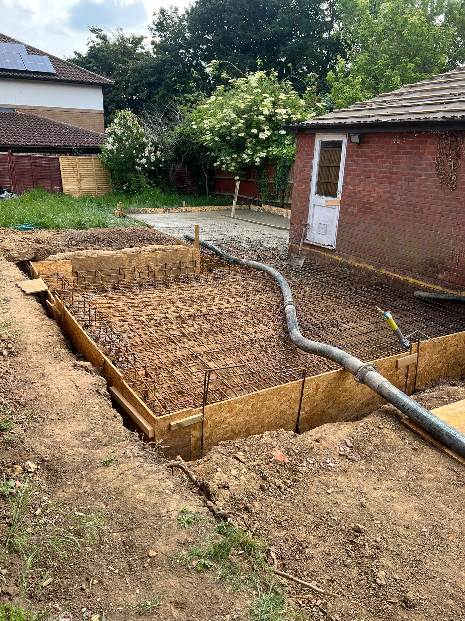 Steel-reinforced footings dug and shuttered ready for concrete on a Milton Keynes man and digger groundwork job.